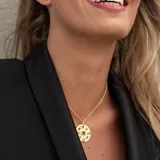 Collar dorado con colgante circular con diseño de ojo y piedras turmalinas multicolor y topacio blanco.