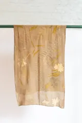 Pañuelo de seda natural color verde romerillo, con impresión botánica de hojas de helecho y malvarrosa.