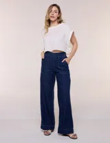 Jean de tiro alto y pierna amplia de corte wide leg, confeccionado en denim azul. Presenta cintura plana en el frente y elastizada en la espalda, bolsillos delanteros aplicados estilo parche y pespuntes a contrapunto.