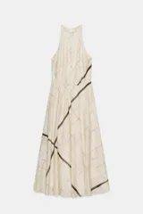 Vestido midi de cuello halter con diseño de cuadros, cintura elástica y abertura en la espalda. Cuenta con cierre de cremallera oculta y botón en la parte posterior.