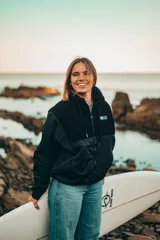 Campera negra con paneles de tela lisa y de corderito, cierre frontal y cuello alto.