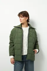 Campera marrón capitoneada de manga larga con cuello alto de tela, cierre frontal y bolsillos laterales con cierre.