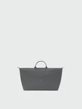 Bolso de viaje de gran tamaño, modelo Le Pliage One de Longchamp, en color marrón. Presenta el diseño icónico de la marca con solapa de cuero, asas cortas y cierre de cremallera superior.