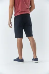 Bermuda clásica de jean color beige, con cinco bolsillos, cierre con cremallera y botón.