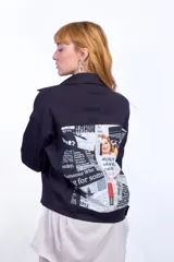 Campera negra alicrada con aplique de estampa de recortes de diario en la espalda.