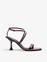 Sandalias de taco fino color bordó, confeccionadas en cuero vacuno satinado con tiras finas y pulsera enlazada al tobillo.