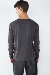 Camiseta de manga larga con cuello en V, confeccionada en tejido con efecto lavado desgastado.