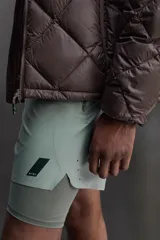 Shorts de entrenamiento azul marino con calza interior negra. Cintura elástica ajustable con cordón, bolsillos laterales con cierre y aberturas laterales en el bajo.