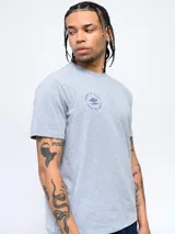 Remera de manga corta color blanco con cuello redondo. Presenta un pequeño logo circular de Umbro estampado en el pecho con la leyenda 'Born to Play'.