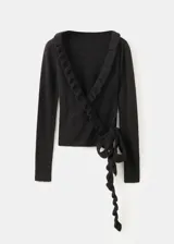 Cardigan negro de punto con escote en V cruzado, volados decorativos en los bordes y mangas largas con puños extendidos.