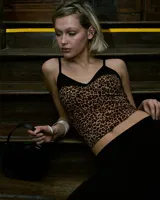 Top ajustado con estampado animal print, breteles finos y escote en V con ribete negro.