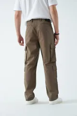Pantalón cargo de canvas color marrón, con tiro medio, múltiples bolsillos laterales y traseros, y cierre frontal con botón y cremallera.