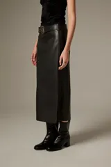 Falda midi de eco-cuero negro con corte recto y tajo lateral, incluye cinturón con hebilla metálica.