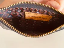 Billetera tarjetero de cuero con cierre y espacio para billetes y monedas.