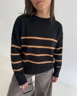 Sweater de tejido bremer a rayas horizontales en color negro y tostado, con cuello redondo y mangas largas.
