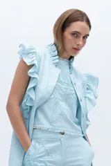 Blusa negra de lino con bordado en relieve de formas orgánicas, mangas cortas con volados y terminaciones desflecadas.