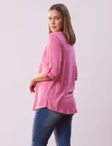 Blusa Ninety color beige con textura, cuello base con escote en V y abertura central con botones. Tiene un bolsillo en el pecho y mangas 3/4 regulables con presilla y botón.