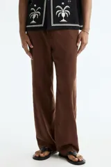 Pantalón de corte relajado color marrón, confeccionado en mezcla de lino y viscosa, con cintura elástica ajustable mediante cordón y bolsillos laterales.