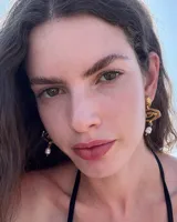 Aros colgantes de bronce dorado con diseño orgánico y perla de río natural en el extremo inferior.