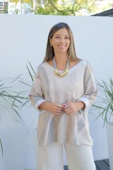 Sweater de punto con diseño de ondas en tonos beige y gris, de corte amplio, escote en V y mangas largas con puños vueltos.