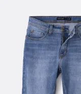 Pantalón de jean corte slim, con diseño clásico de cinco bolsillos, cierre frontal con cremallera y botón, y costuras reforzadas.