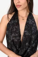 Top halter negro con diseño estampado y escote drapeado.
