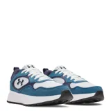 Championes Under Armour modelo Mirage Sport, con diseño deportivo en combinación de colores blanco, azul y azul marino. Presentan paneles de gamuza y malla, con el logo de la marca en el lateral y la lengüeta, y suela de goma blanca con base negra.