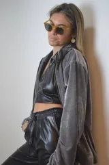 Campera gris de terciopelo con cierre frontal, cuello alto y mangas largas con puños elásticos.