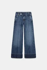 Jeans de tiro bajo con pernera recta y bajo con vuelta. Cuenta con cinco bolsillos y cierre frontal con cremallera y botones.
