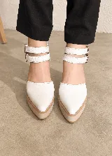 Zapatos de tacón alto color blanco con plataforma y punta fina, diseño destalonado y doble tira ajustable en el tobillo con hebillas metálicas.