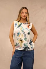 Blusa sin mangas de diseño fluido, color crudo con estampado botánico y floral en tonos azules, verdes, amarillos y naranjas.