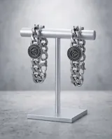 Pulsera de eslabones gruesos de acero con dije central circular que presenta un diseño de nudo celta en relieve.