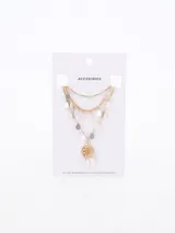 Collar dorado de tres hilos con dijes colgantes en forma de lágrima y un dije central con diseño calado.