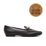 Zapato casual de cuero negro con detalle de hebilla dorada.