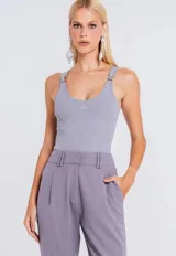 Musculosa de tejido canelado en color gris, con escote redondo y breteles con hebillas metálicas decorativas en los hombros.