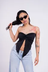 Top strapless blanco con nudo central y corte irregular.