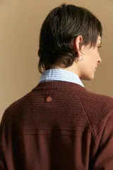 Cardigan de tejido de punto color rojo, con cuello redondo, cierre frontal de botones al tono y puños acanalados.