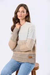 Buzo tejido de punto con diseño de rayas horizontales en tonos gris, rosa, malva y beige. Presenta cuello redondo, mangas largas y puños acanalados, con una pequeña etiqueta de cuero sintético en el ruedo.