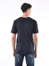 Remera de corte oversize, con diseño bicolor que combina blanco y beige. Presenta un bolsillo frontal en el pecho con el logo de la marca bordado y una etiqueta pequeña en el ruedo.