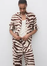 Pantalón fluido de tiro medio con estampado de cebra, diseño recto y largo, cintura elástica con cordón de ajuste y forro interior de algodón.