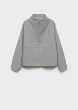 Anorak de diseño oversize en color gris, con cuello chimenea y cierre frontal de cremallera. Presenta mangas largas y ruedo elástico, confeccionado en tejido con acabado estructurado.