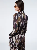 Chaqueta sastrera con estampado abstracto en tonos marrón, beige, azul y negro. Presenta solapa delantera de satén, mangas largas con hombreras y lazo para ajustar en la cintura.
