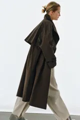 Trench oversize de Zara Woman Collection, confeccionado en mezcla de algodón con estampado de cuadros pequeños. Presenta cuello alto, cierre frontal con botones, mangas largas con trabillas ajustables y bolsillos laterales.