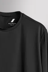 Camiseta deportiva de manga larga Zara Athleticz, de corte regular fit y color marrón topo. Confeccionada en tejido técnico elástico de secado rápido, cuenta con cuello redondo y detalle de logo estampado en el bajo.