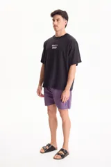 Remera negra de manga corta, confeccionada en algodón, con calce semi boxy y pequeño estampado frontal con la frase "away for a while".
