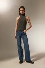 Top tejido de punto color gris oscuro con cuello alto tipo polera y diseño sin mangas con corte halter.