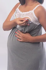 Camisón maternal de modal gris con detalle de puntilla blanca en el escote. Presenta breteles regulables con clip para lactancia y un diseño holgado pensado para la etapa de gestación.