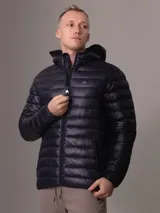 Campera acolchada con capucha de Calvin Klein, color azul marino, con cierre frontal y bolsillos laterales con cremallera. Diseño ligero y funcional con logo de la marca en el pecho.