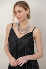 Vestido largo negro de satén plisado, con tirantes finos y escote en V.