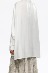 Camisa oversize de manga larga, color blanco, confeccionada en viscosa brillante. Presenta cuello camisero, cierre frontal de botones y dos bolsillos de parche en el pecho.